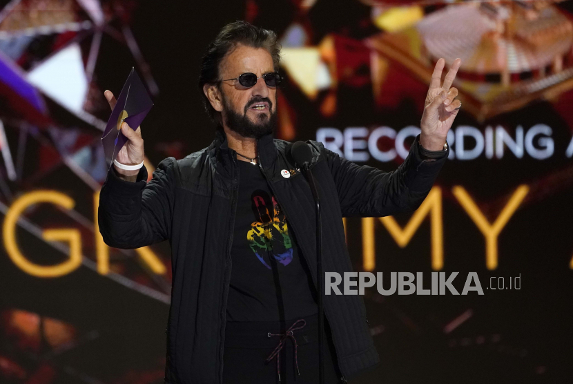 Ringo Starr memberi isyarat saat dia mempersembahkan penghargaan untuk rekor tahun ini di Grammy Awards tahunan ke-63 di Los Angeles Convention Center pada hari Ahad, 14 Maret 2021. Starr membatalkan konsernya di AS setelah mendadak sakit.