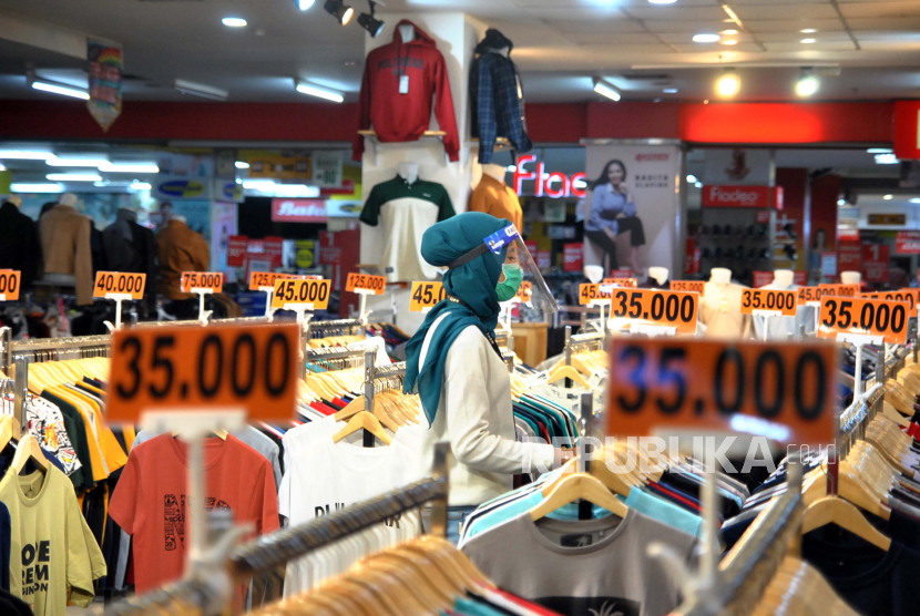 Penjaga toko menggunakan masker dan alat pelindung wajah (Face Shield) saat pembukaan kembali pusat perbelanjaan Mall BTM, Kota Bogor, Jawa Barat. Ahli sarankan jaga jarak dua meter dan wajib masker saat berbelanja di mall atau pasar
