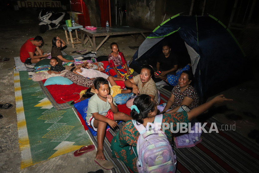 Warga mengungsi di halaman rumahnya pascagempa di Sangkapura, Pulau Bawean, Gresik, Jawa Timur, Sabtu (23/3/2024). Sebagian warga korban gempa bumi memilih mengungsi di halaman rumah mereka untuk mengantisipasi terjadinya gempa susulan. 