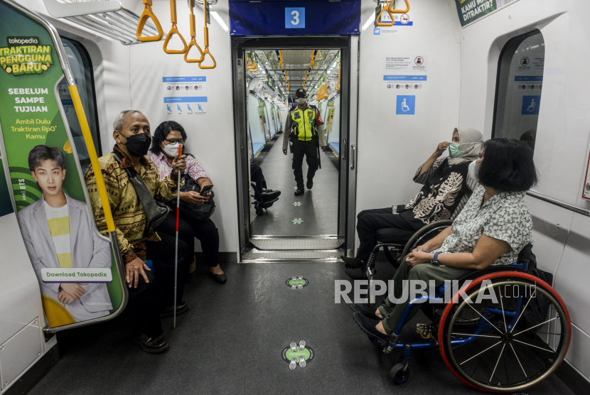 Penyadang disabilitas saat menaiki rangkaian MRT Jakarta di Stasiun Bundaran HI, Jakarta Pusat, Jumat (3/12). 