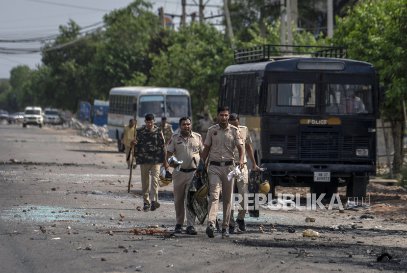 Pecahan kaca dan puing-puing berserakan di jalan saat polisi berpatroli setelah bentrokan komunal di Nuh di negara bagian Haryana, India, Selasa, 1 Agustus 2023. Bentrokan mematikan antara umat Hindu.