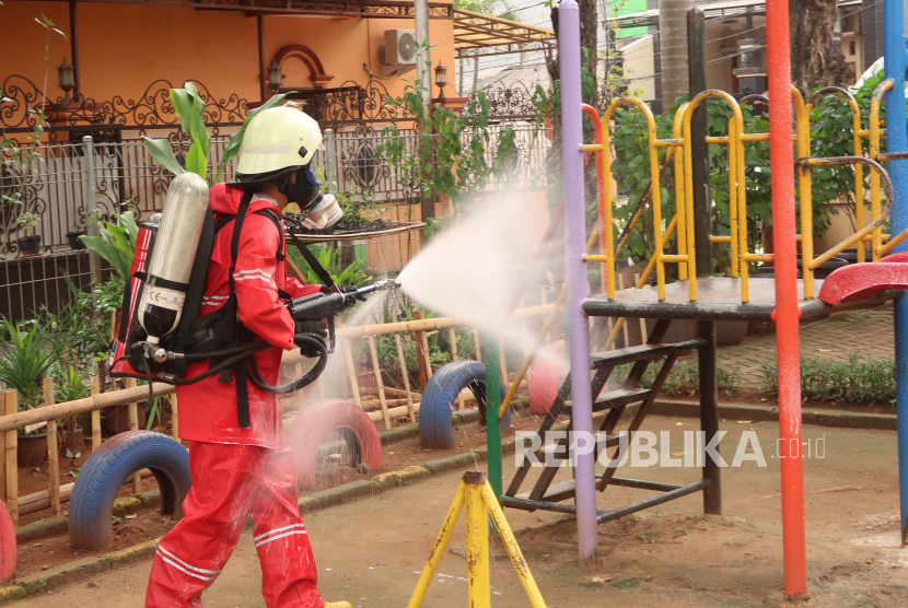 Petugas damkar (pemadam kebakaran) melakukan penyemprotan desinfektan.