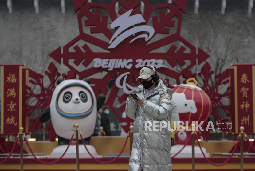  Seorang wanita mengenakan masker berjalan melewati Bing Dwen Dwen, Maskot Olimpiade Musim Dingin Beijing 2022 dan Shuey Rhon Rhon, Maskot Paralimpiade Musim Dingin Beijing 2022, di Beijing, Cina, 24 Januari 2022. 