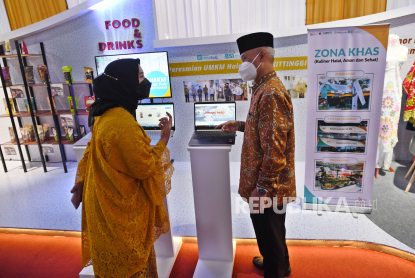 Wakil Direktur Utama Bank Syariah Indonesia (BSI) Ngatari (kanan) meninjau stan Zona Kuliner Halal, Aman, dan Sehat (KHAS) dalam acara Gerakan Nasional (Gernas) Bangga Buatan Indonesia (BBI) di Bukittinggi, Sumatera Barat, Selasa (12/4/2022). Otoritas Jasa Keuangan (OJK) menggandeng Bank Syariah Indonesia (BSI) untuk mewujudkan program Zona Kuliner Halal Aman dan Sehat (KHAS) di Kota Bukittinggi sebagai upaya mengembangkan keuangan dan ekonomi syariah. 