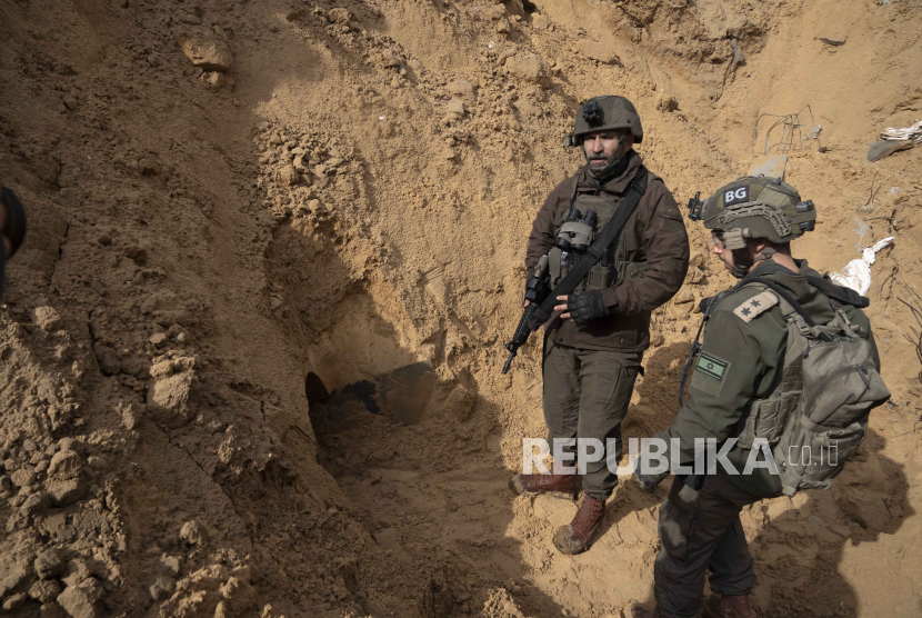 Brigadir Jenderal Israel Dan Goldfus, kiri, berdiri di dekat terowongan Hamas di bawah kuburan selama serangan darat di Jalur Gaza di Khan Younis, Sabtu, (27/1/2024).