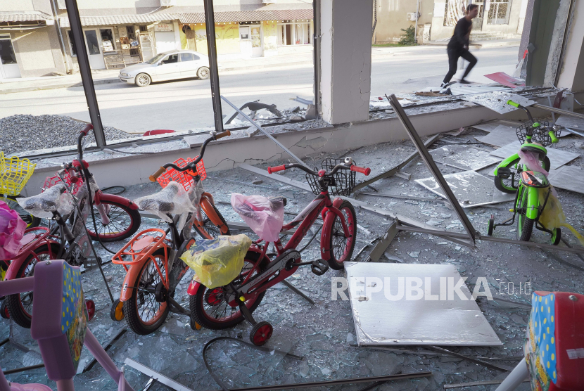 Seorang pria memasuki toko dengan sepeda anak-anak, rusak akibat tembakan artileri Azerbaijan selama konflik militer di kota garis depan Martakert, wilayah separatis Nagorno-Karabakh, Senin, 19 Oktober 2020.