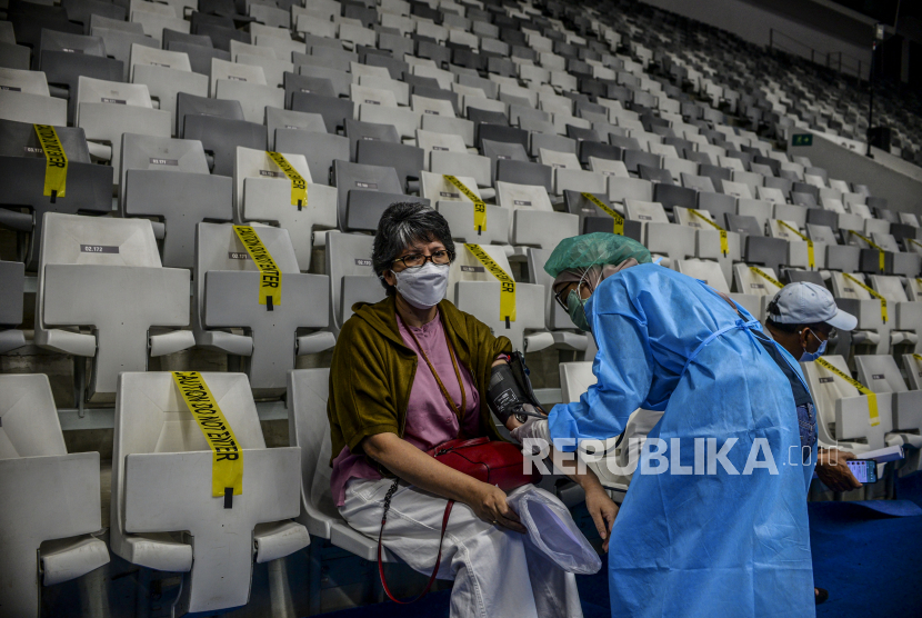 Tenaga kesehatan memeriksa kesehatan lansia yang melaksanakan vaksin di Sentra Vaksinasi Bersama Istora Senayan, Jakarta Pusat, Jumat (19/3).