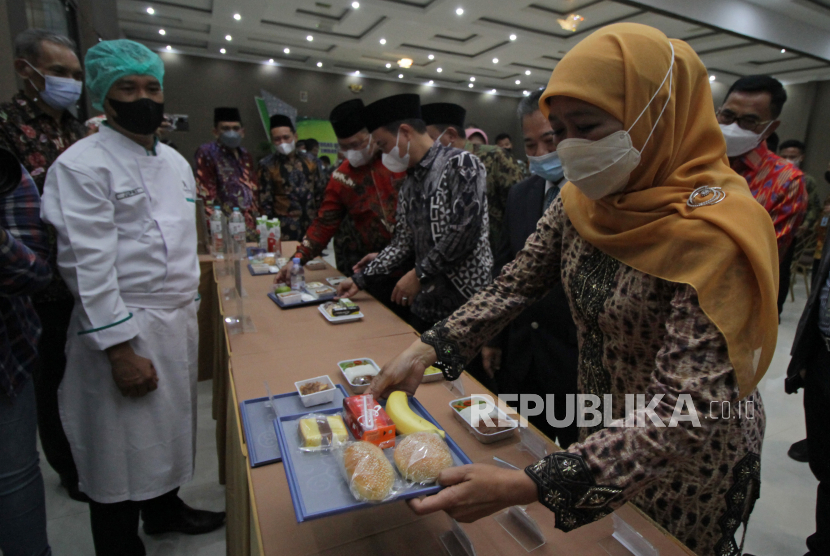 Gubernur Jawa Timur Khofifah Indar Parawansa (kanan) melihat sejumlah menu hidangan yang akan disajikan kepada jemaah haji di sela-sela Pengukuhan Petugas Penyelenggara Ibadah Haji (PPIH) Embarkasi Surabaya dan 