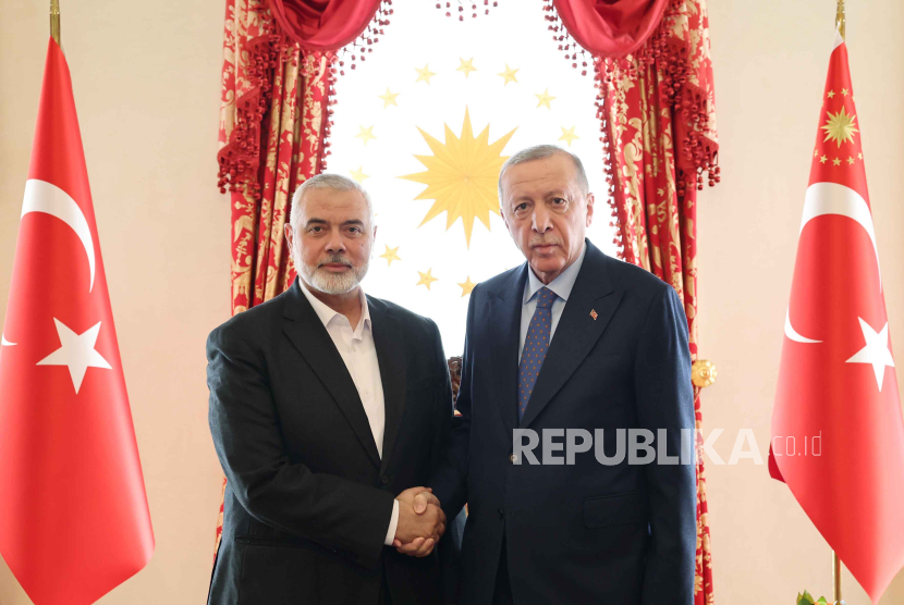 Foto selebaran yang disediakan oleh Kantor Pers Kepresidenan Turki menunjukkan Presiden Turki Recep Tayyip Erdogan (kanan) dan pemimpin Hamas Ismail Haniyeh (kiri) berjabat tangan.