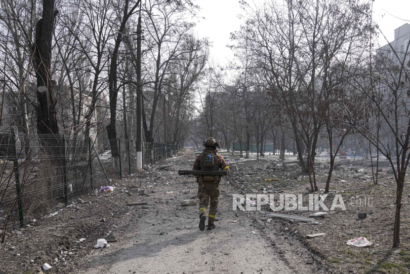 Seorang prajurit Ukraina berjalan di dekat posisi yang dia jaga di Mariupol, Ukraina, Sabtu, 12 Maret 2022.