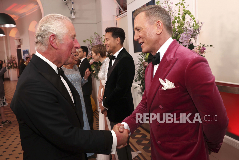 Charles yang waktu itu masih bergelar pangeran (kiri) berjabat tangan dengan aktor Daniel Craig di pemutaran perdana dunia film James Bond baru No Time To Die di Royal Albert Hall di London, Inggris, Selasa, 28 September 2021. Craig mendapat penghargaan dari kerajaan Inggris. Penghargaannya sama seperti yang didapat oleh tokoh fiktif James Bond di film.