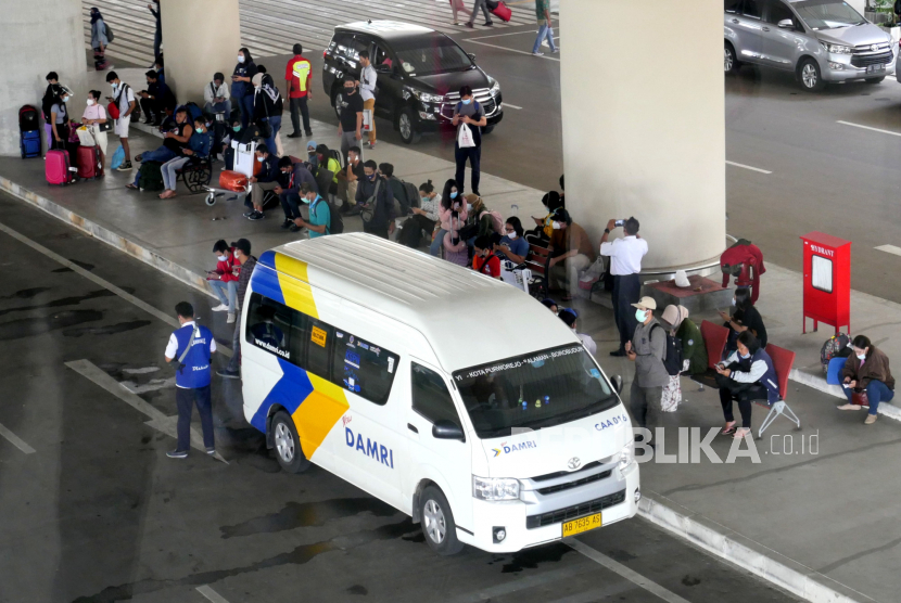 Penumpang pesawat menunggu moda angkutan Damri di Bandara Internasional Yogyakarta (YIA), Kulonprogo, Rabu (23/12). 
