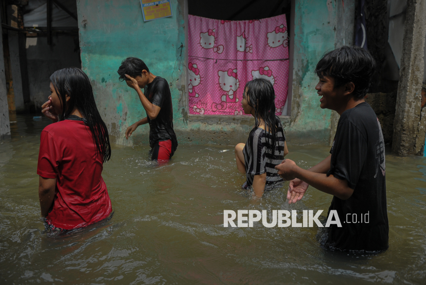 Warga beraktivitas saat banjir merendam permukimannya di kawasan Kampung Baru I, Kecamatan Makasar, Jakarta Timur, Jakarta, Senin (7/7/2025). Banjir yang menggenangi kawasan permukiman tersebut terjadi pada Ahad (6/7) sekitar pukul 17.00 WIB yang diduga akibat intensitas hujan tinggi yang menyebabkan luapan kali Cipinang. Hingga saat ini, genangan banjir di kawasan tersebut masih setinggi sekitar 50 centimeter. Menurut warga, sebanyak 95 kepala keluarga terdampak banjir selama hampir 20 jam yang menyebabkan sejumlah aktivitas warga terkendala. Berdasarkan data Badan Penanggulanan Bencana Daerah (BPBD) DKI Jakarta, banjir di Jakarta meluas di 109 RT dengan sebaran titik 17 RT di Jakarta Pusat, 15 RT di Jakarta Barat, 30 RT di Jakarta Selatan dan 47 RT di Jakarta Timur.