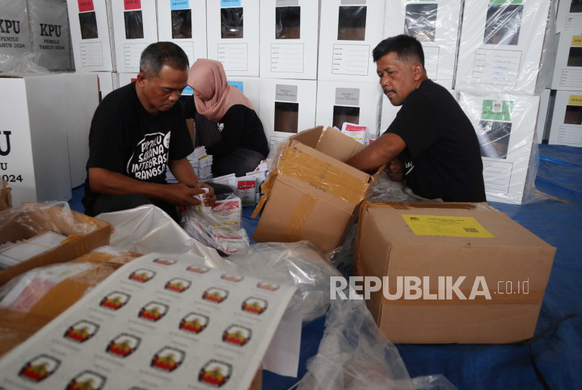 Tiga petugas mengemas logistik Pemilu 2024 di GOR Merdeka Kabupaten Jombang, Jawa Timur