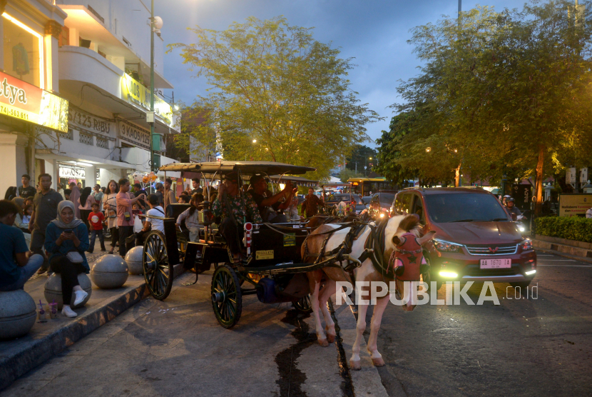 Andong membawa wisatawan berkeliling di kawasan wisata ikonik Malioboro, Yogyakarta.