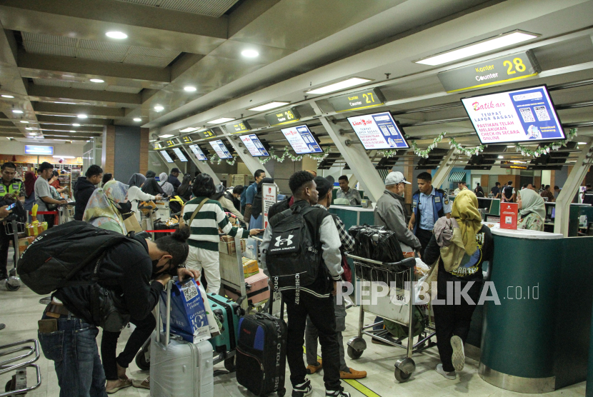 Calon penumpang mengantre untuk melakukan lapor diri (check-in) di terminal keberangkatan Bandara Internasional Sultan Hasanuddin, Maros, Sulawesi Selatan, Jumat (22/12/2023). 