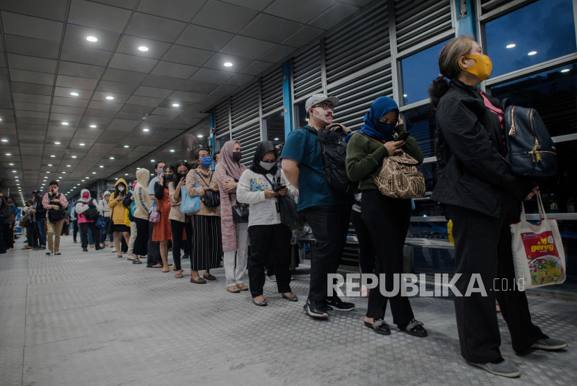 Sejumlah calon penumpang mengantre menunggu bus Transjakarta. Penumpang yang sebagian besar adalah pekerja kantoran terpapar risiko Covid-19 dan berpotensi menularkan setibanya di tempat kerja. Pada Rabu (29/7), tercatat klaster perkantoran di Jakarta menyumbang 459 kasus positif Covid-19.