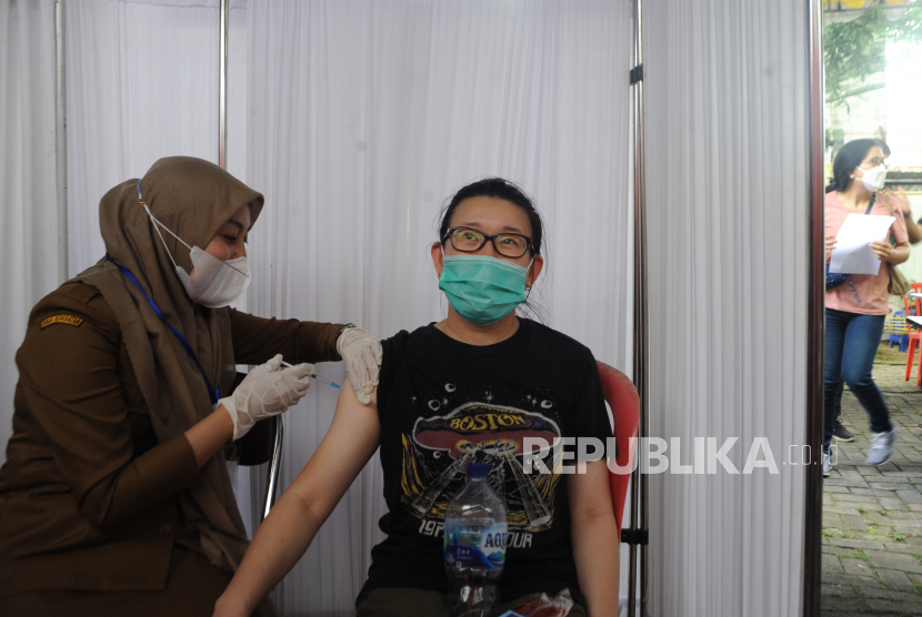 Petugas menyuntikkan vaksin COVID-19 kepada salah satu penerima vaksin saat kegiatan vaksin bersama lintas agama yang diselenggarakan Forum Kerukunan Umat Beragama (FKUB) Sumatra Selatan di Klinik Budi Mulia Palembang, Sumatera Selatan, Selasa (6/4/2021). Sekitar 400 orang warga dari berbagai latar belakang agama menerima  vaksin pada kesempatan tersebut. 