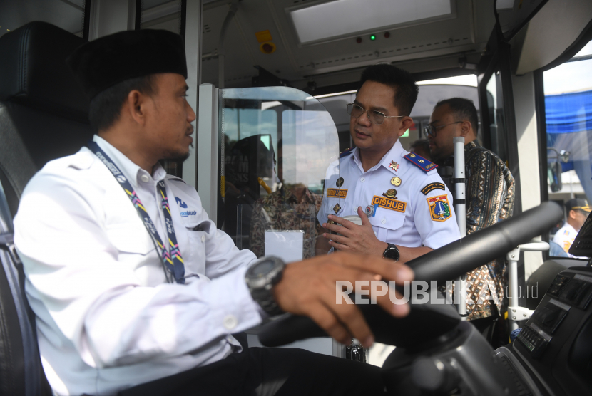 Kepala Dinas Perhubungan DKI Jakarta Syafrin Liputo (kanan) berbincang dengan supir bus listrik Transjakarta saat peluncuran uji coba bus di Pool Transjakarta, Terminal Kampung Rambutan, Jakarta Selatan, Rabu (8/6/2022). 