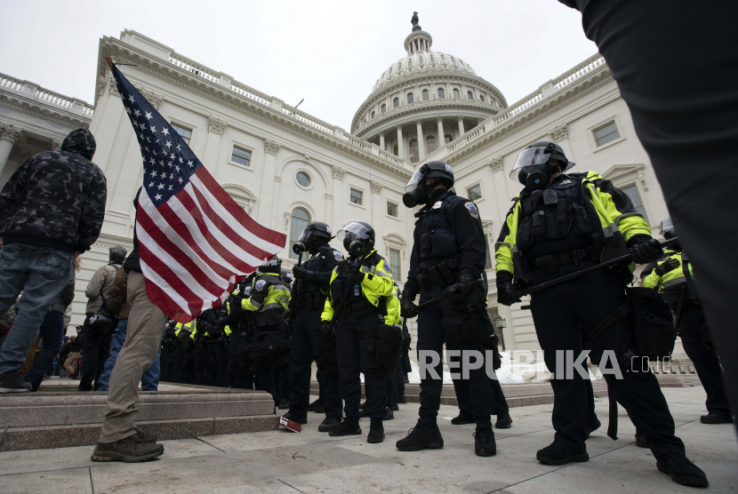  Petugas Kepolisian Capitol AS mendorong kembali demonstran yang mencoba masuk ke Capitol AS pada hari Rabu, 6 Januari 2021, di Washington.