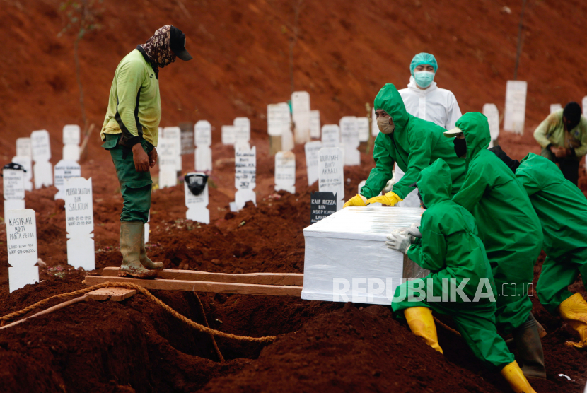 [Ilustrasi] Pekerja menurunkan peti mati seseorang yang meninggal karena COVID-19 saat upacara pemakaman di Makam Pondok Ranggon di Jakarta, Indonesia, 30 September 2020.