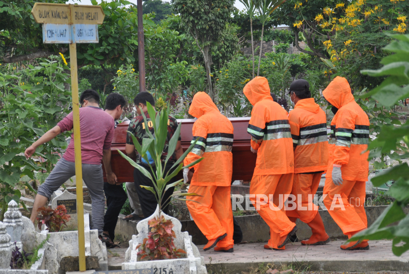 Medan Siapkan Pemakaman Khusus Jenazah Covid-19. Petugas penggali kubur menggunakan alat pelindung diri (ADP) bersama kerabat keluarga memakamkan Pasien Dalam Pengawasan (PDP) Covid-19 di Medan, Sumatra Utara.