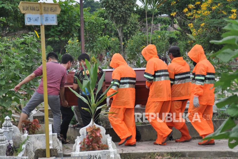 Petugas penggali kubur menggunakan alat pelindung diri (ADP) bersama kerabat keluarga memakamkan Pasien Dalam Pengawasan (PDP) Covid-19 (ilustrasi)