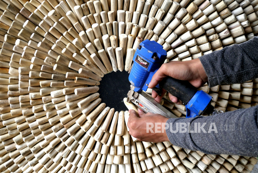 Pengerajin membuat hiasan dinding dari limbah kayu di Marendra Craft Limbah Kayu, Wirokerten, Bantul, Yogyakarta, Rabu (21/10). 