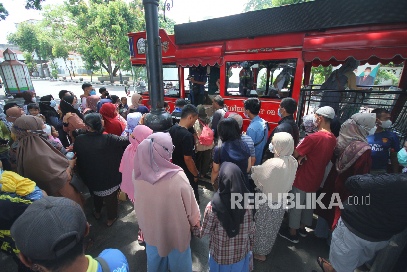 Wisatawan libur lebaran antri naik Bandros (Bandung Tour On Bus) di kawasan Taman Alun-alun Kota Bandung.