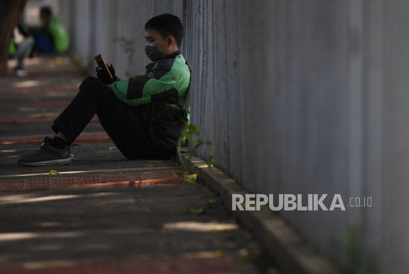 Pengemudi ojek daring menunggu orderan. Gubernur DKI Jakarta Anies Baswedan mengatakan sedang menunggu keputusan pemerintah pusat terkait izin operasi ojek di kala pembatasan sosial berskala besar (PSBB). 