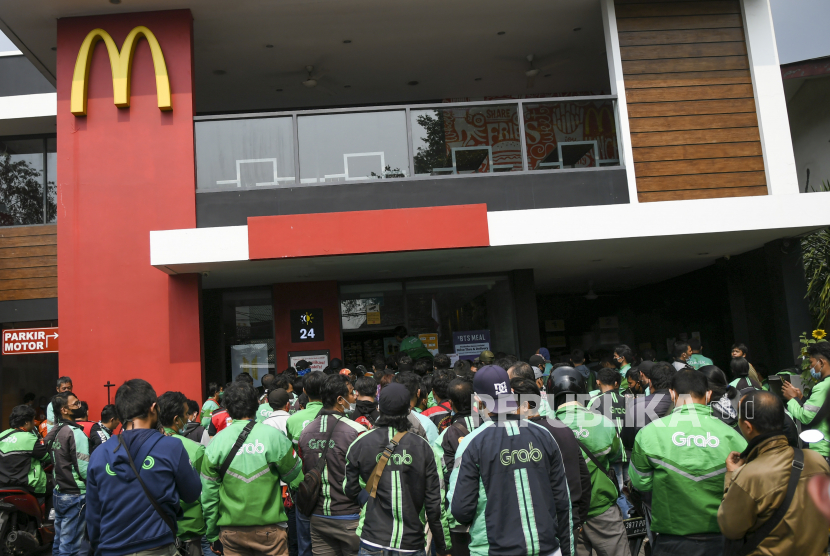 Pengemudi ojek daring memadati gerai McDonald’s Raden Saleh di Jakarta, Rabu (9/6/2021). Puluhan pengemudi  ojek daring tersebut terlihat mengabaikan protokol kesehatan saat mengantre untuk mengambil pesanan BTS Meal yang merupakan menu kolaborasi 