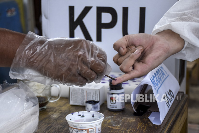 Petugas KPPS meneteskan tinta kepada pemilih usai melakukan pencoblosan di TPS. (Ilustrasi)