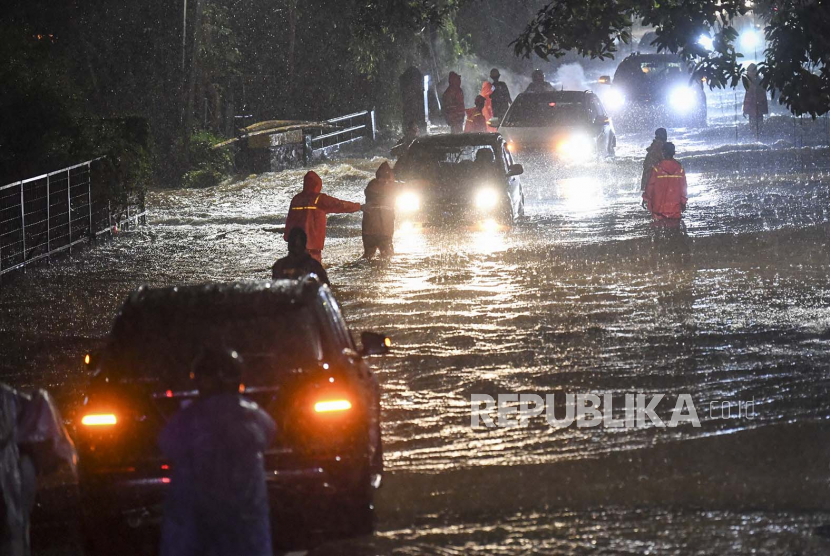 Petugas Penanganan Prasarana dan Sarana Umum (PPSU) mengimbau pengendara mobil saat menerjang banjir di kawasan Jeruk Purut, Jakarta Selatan, Kamis (6/10/2022). Sejumlah daerah di Jakarta terendam banjir akibat timngginya intensitas hujan yang melanda daerah tersebut.