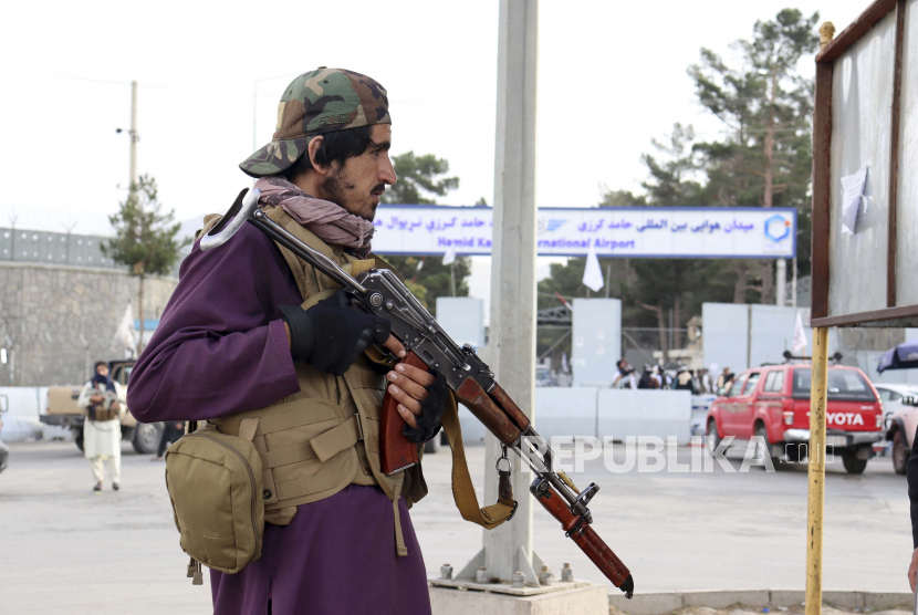  Seorang pejuang Taliban berjaga di depan Bandara Internasional Hamid Karzai setelah penarikan AS di Kabul, Afghanistan, Selasa, 31 Agustus 2021. Taliban menguasai penuh bandara internasional Kabul pada Selasa, setelah pesawat AS terakhir meninggalkannya landasan pacu, menandai berakhirnya perang terpanjang Amerika.