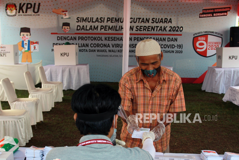 Ketua Kelompok Penyelenggara Pemungutan Suara (KPPS) memberikan surat suara kepada pemilih saat dilaksanakan Simulasi Pemungutan Suara dengan Protokol Kesehatan Pencegahan dan Pengendalian COVID-19 pada Pilkada Serentak 2020,  di TPS 18 Cilenggang, Serpong, Tangerang Selatan, Banten, Sabtu (12/9). Pilkada serentak 2020 diprediksi akan memunculkan klaster dan meningkatkan jumlah kasus Covid-19 di Indonesia. (ilustrasi)
