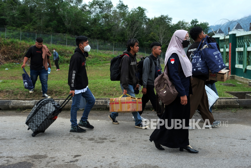 Sejumlah Pekerja Migran Indonesia (PMI) asal Sambas berjalan menuju pintuk masuk perbatasan Malaysia melalui Pos Lintas Batas Negara (PLBN) Terpadu Aruk di Kabupaten Sambas, Kalimantan Barat, Selasa (18/10/2022). Kementerian Dalam Negeri Malaysia sedang menyelesaikan penetapan pintu masuk baru antara Indonesia dan Malaysia.