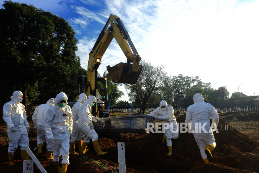 Petugas mengangkat peti jenazah Covid-19 dibantu alat berat di pemakaman khusus Covid-19, Macanda, Kabupaten Gowa, Sulawesi Selatan, Selasa (27/7/2021). Satgas Penanganan Covid-19 mengungkapkan, bahwa jumlah kematian Covid-19 pada Juli 2021 adalah yang tertinggi selama pandemi. (ilustrasi)