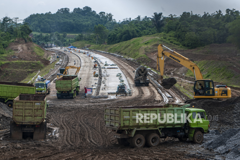 Pekerja menggunakan alat berat menyelesaikan proyek pembangunan tol Rangkasbitung-Panimbang seksi II di Lebak, Banten, Ahad (26/2/2023).