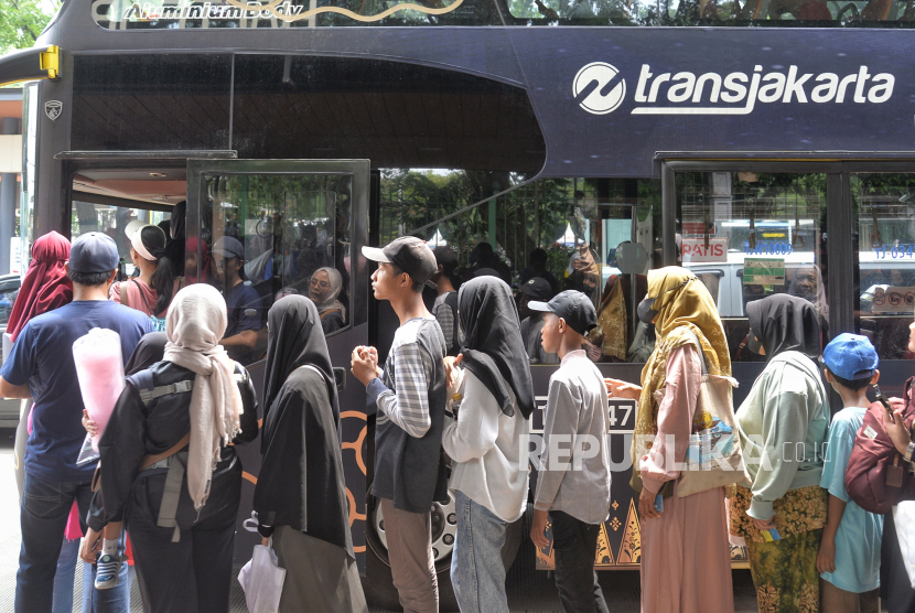 Warga mengantre untuk menaiki Bus Transjakarta di Kawasan Monas, Jakarta, Senin (1/1/2024). Transjakarta mengangkut 280 juta penumpang pada 2023.