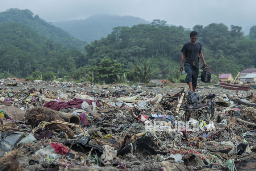Warga melintas di sekitar tumpukan sampah di Pantai Cibutun Loji, Desa Sangrawayang, Simpenan, Kabupaten Sukabumi, Jawa Barat, Sabtu (11/5/2024). 