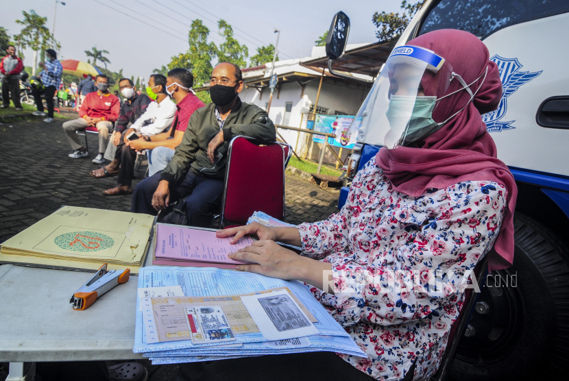 Petugas melayani warga melakukan perpanjangan SIM di pelayanan SIM Keliling di Masjid At-Tin, Jakarta Timur, Rabu (10/6). 