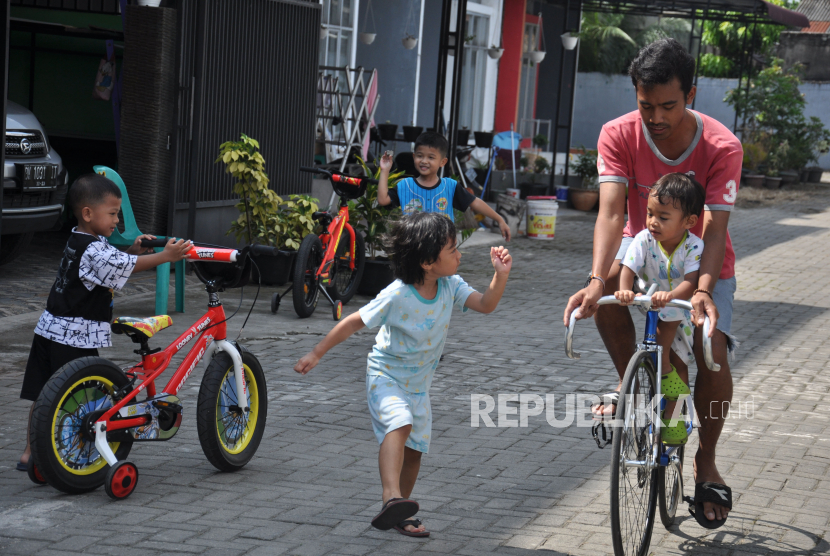 Seorang bapak bermain bersama anak-anak di Medan, Sumatera Utara, Kamis (26/3/2020). Masyarakat merupakan garda terdepan pemutus rantai penularan covid-19 dan diimbau menghindari pertemuan dengan banyak orang atau kerumunan orang. 