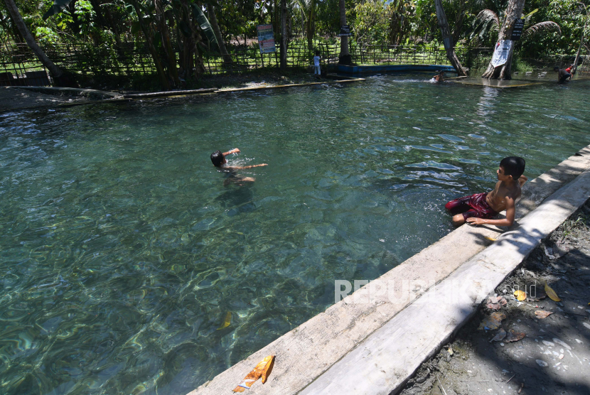 Sejumlah anak berenang di kolam pemandian mata air Bionga di Desa Kaleke, Kabupaten Sigi, Sulawesi Tengah, Jumat (15/10/2021). Kolam permandian mata air menjadi alternatif destinasi wisata di daerah tersebut. 