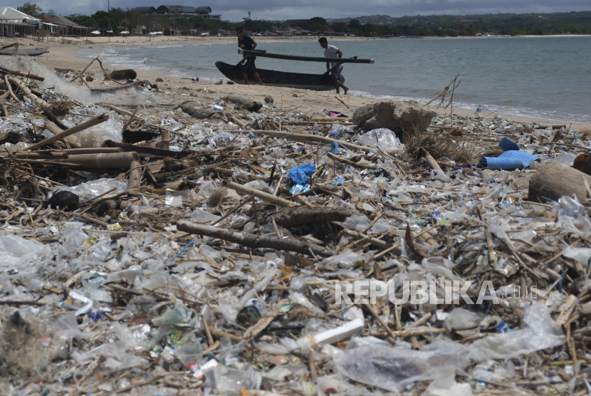 Nelayan mengangkut sampan di dekat tumpukan sampah di Pantai Kedonganan, Badung, Bali.  Laju sampah plastik di Indonesia kian hari akan meningkat, dengan munculnya beragam produk baru berkemasan tidak ramah lingkungan. Diperkirakan pada 2050, jumlah sampah akan lebih banyak dibandingkan jumlah ikan di laut.