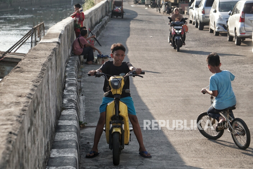 Anak-anak menaiki sepeda listrik di kawasan Jatinegara, Jakarta, Selasa (1/8/2023). 