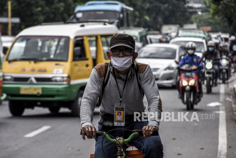 Warga mengenakan masker melintas di pos pemeriksaan Pembatasan Sosial Berskala Besar (PSBB) di Jalan Rajawali, Kota Bandung, Senin (4/5). Pembatasan Sosial Berskala Besar (PSBB) Bandung Raya akan berakhir pada Selasa (5/5)