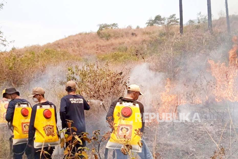 Petugas melakukan proses pemadaman api yang membakar lahan di kawasan Gunung Guntur, Kabupaten Garut, Kamis (7/9/2023). 