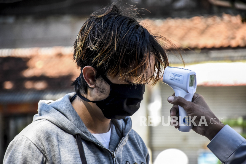 Petugas memeriksa suhu tubuh calon penumpang di Terminal Leuwipanjang, Kota Bandung.
