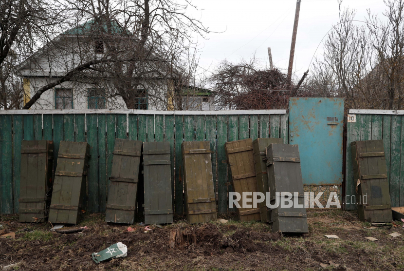 Peti amunisi yang ditinggalkan oleh pasukan Rusia yang mundur bersandar di pagar di desa Andriivka, Ukraina