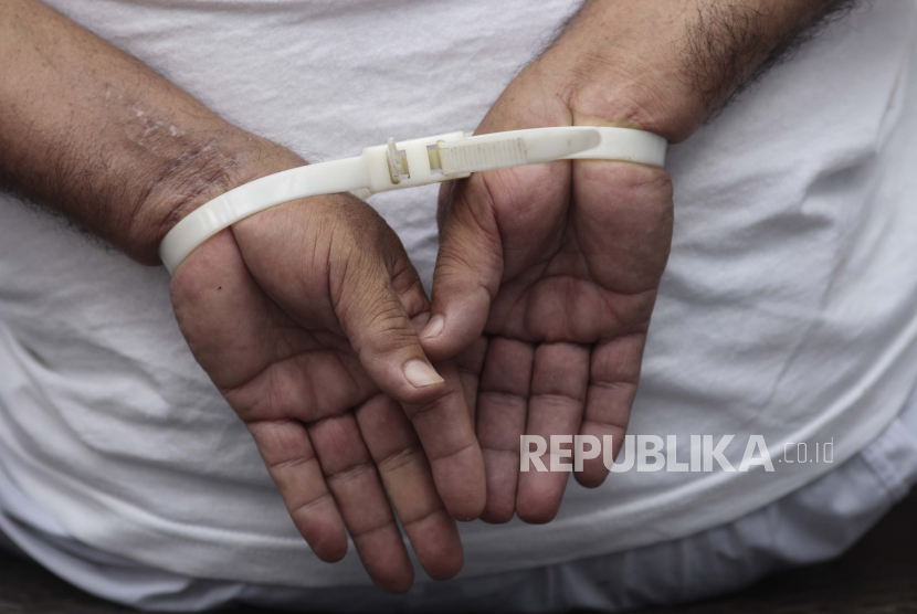 Seorang pria diborgol (Ilustrasi). Seorang tukang ojek di Palembang, Sumatra Selatan ditangkap setelah menyimpan secara online video dan foto kemaluan anak perempuan yang merupakan pelanggan ojeknya.